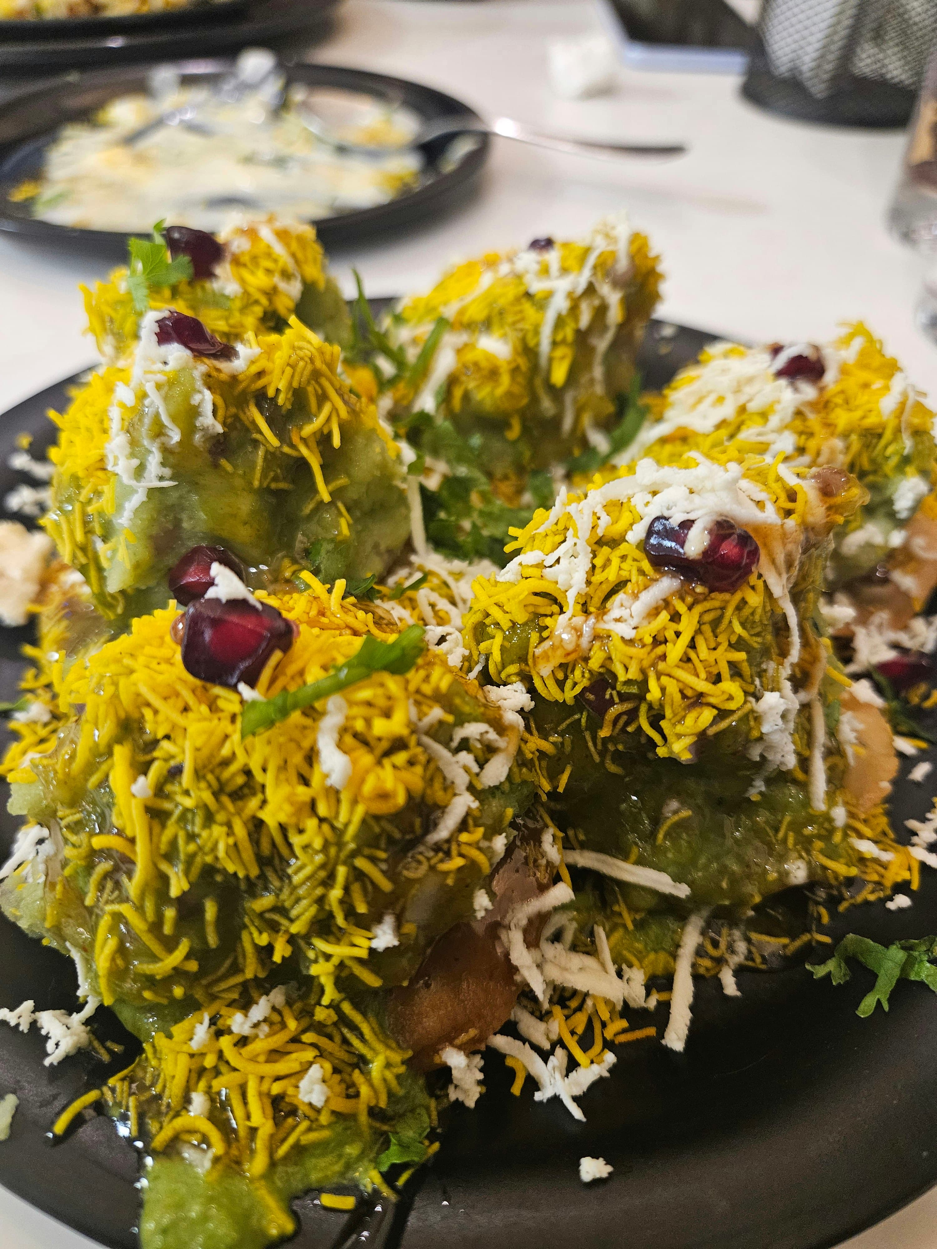 Gujarati steamed dhokla squares with mustard seeds tempering and green chutney